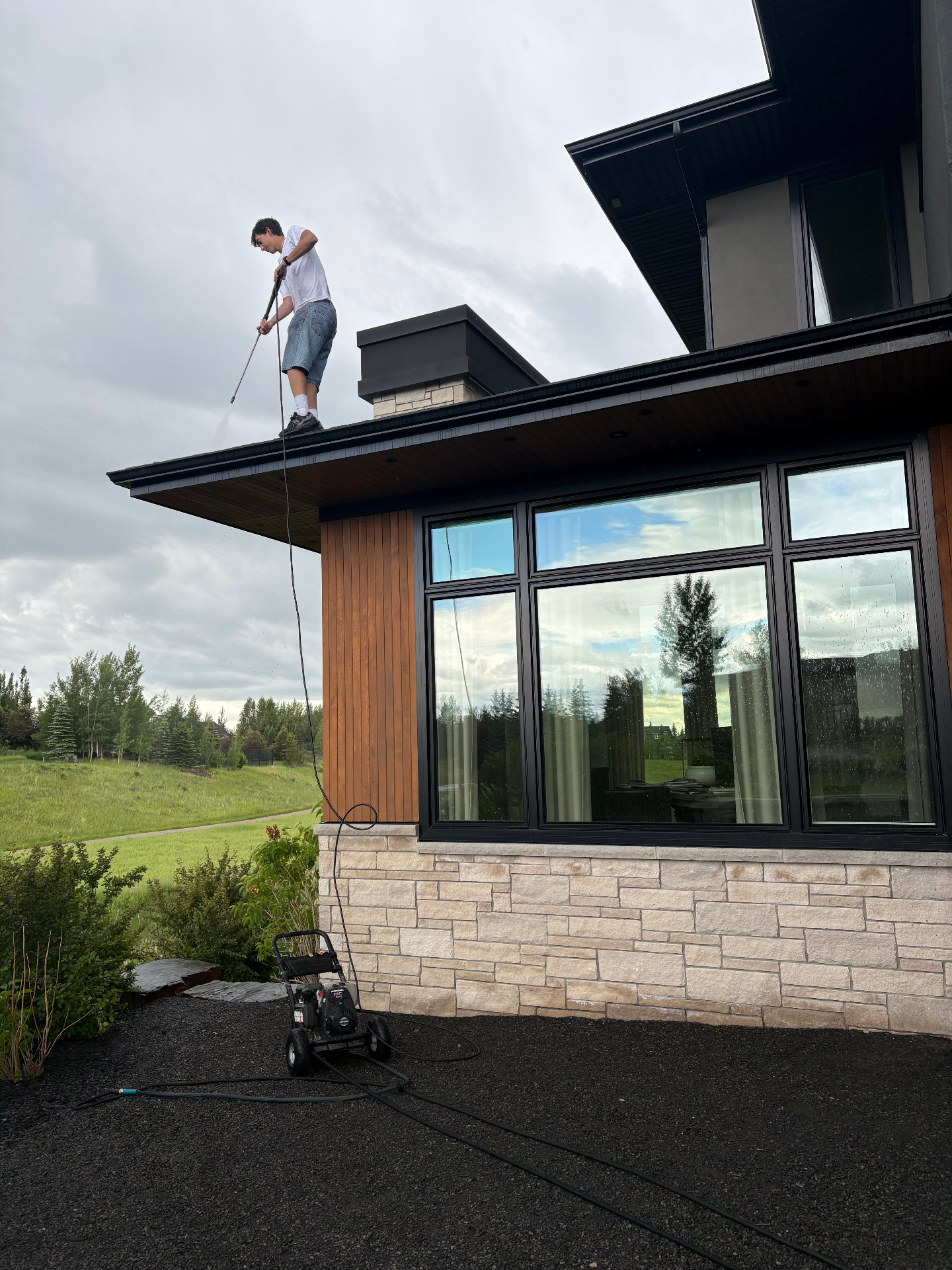 Pressure washing the roof of a modern Calgary home
